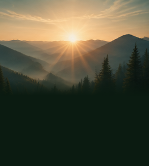 Sunrise above wooded mountain ridges